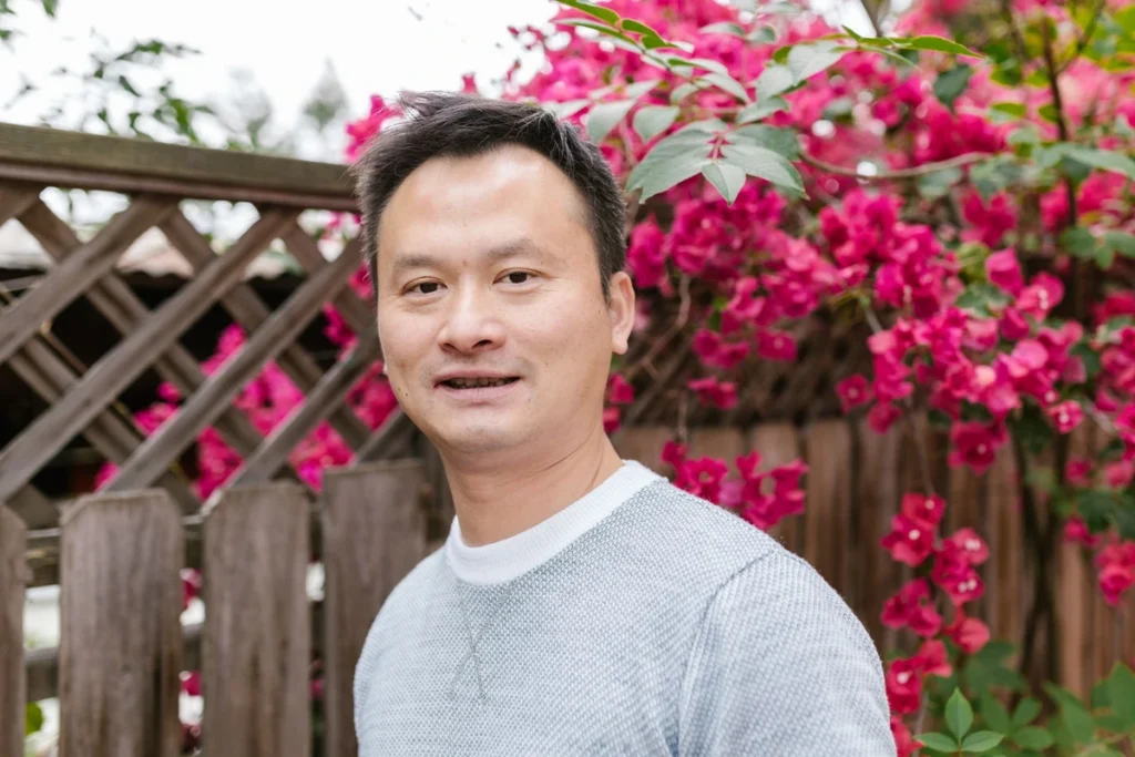 台灣男性受訪者於戶外花牆前的自然光人像，示意雄性素與柔沛用藥評估情境