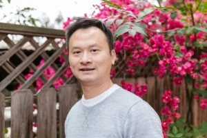 台灣男性受訪者於戶外花牆前的自然光人像，示意雄性素與柔沛用藥評估情境